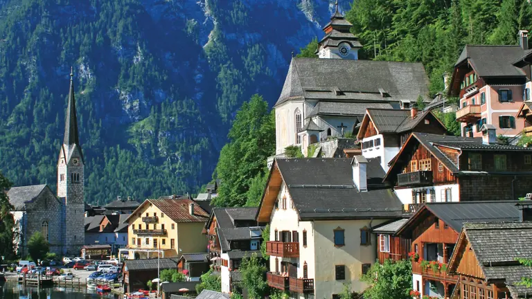 The village of Hallstatt rising in tiers from the lake shore, its slim church spire against a steep forested mountain
