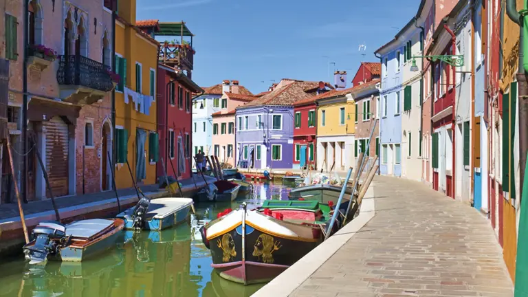 Brightly painted fishermen's houses lining a canal on the lagoon island of Burano near Venice