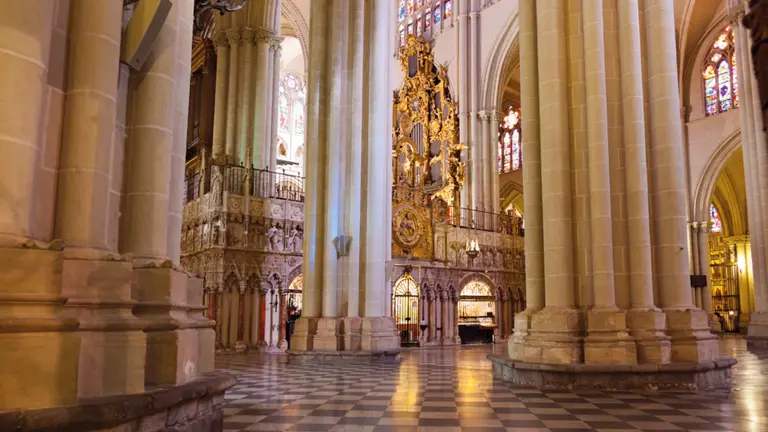The soaring Gothic interior of Toledo Cathedral, with ribbed vaulting and stained glass above the nave