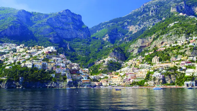 The cascading village of Positano on the Amalfi Coast, multi-coloured vernacular buildings clinging to steep cliffs above turquoise Mediterranean water