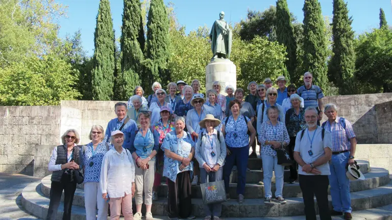 Group of visitors gathered beside a statue of King Afonso Henriques in the historic city of Guimarães, Portugal.