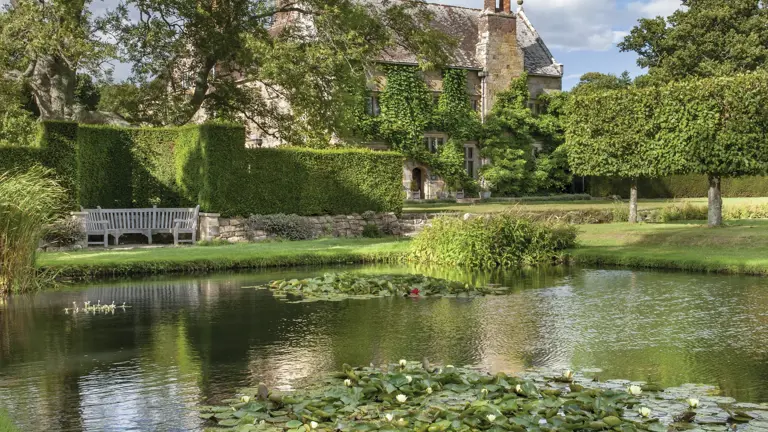 Bateman's — 17th century sandstone manor house in East Sussex, framed by yew hedging and a tile-roofed gable