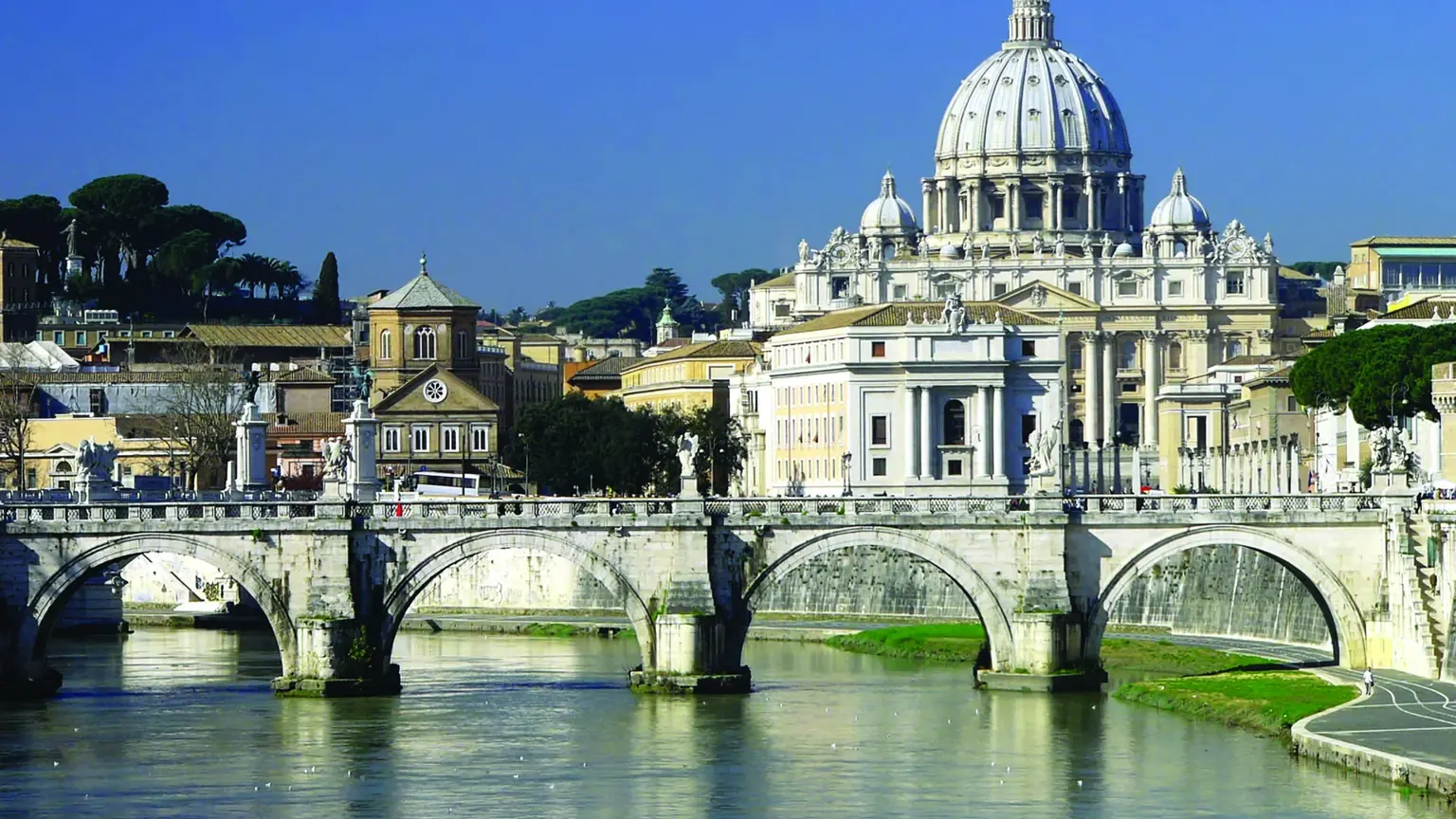 The dome of St Peter's Basilica dominating the Rome skyline, the Tiber and an arched bridge in the foreground