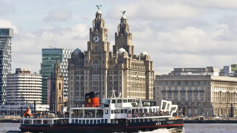 Mersey Ferry crossing the river in front of the Royal Liver Building, with its twin clock towers and Liver Bird statues