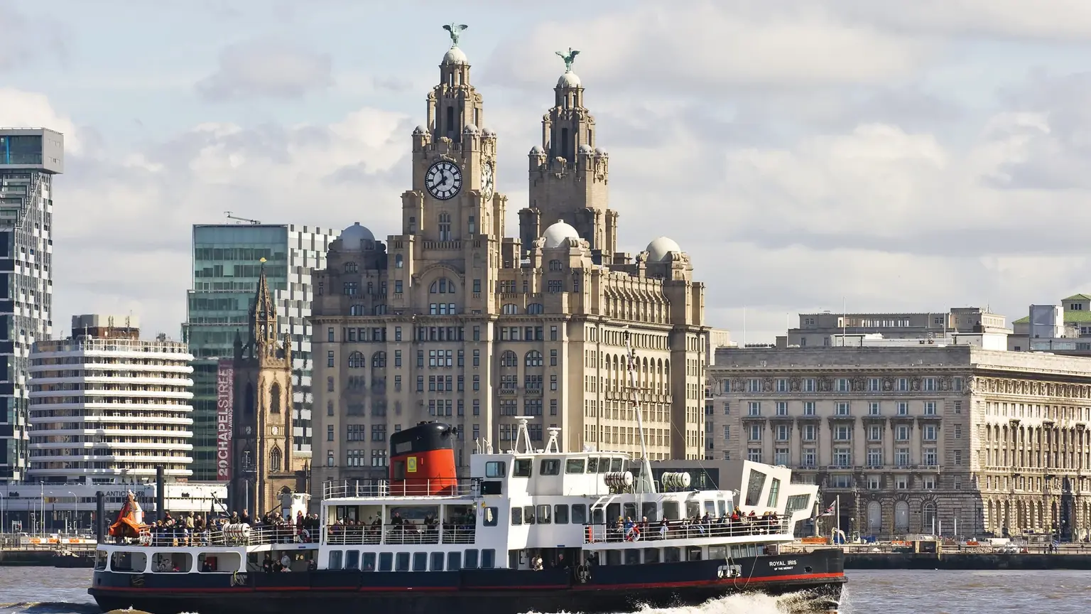 Mersey Ferry crossing the river in front of the Royal Liver Building, with its twin clock towers and Liver Bird statues