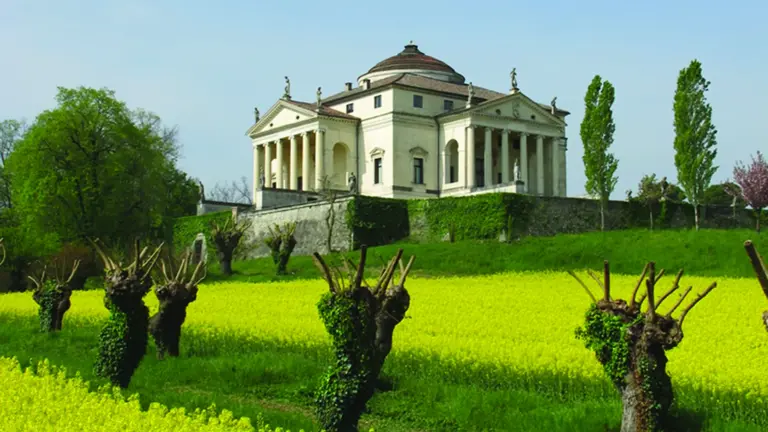 Palladio's white domed Villa La Rotonda near Vicenza, columned porticos on each face, flowering vines in the spring gardens