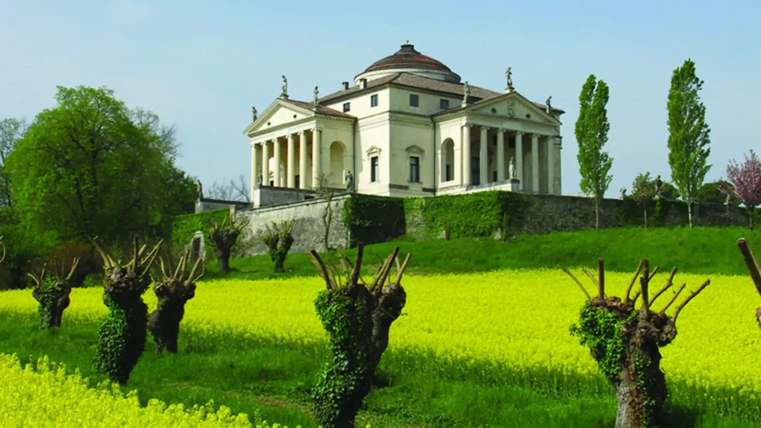 Palladio's white domed Villa La Rotonda near Vicenza, columned porticos on each face, flowering vines in the spring gardens