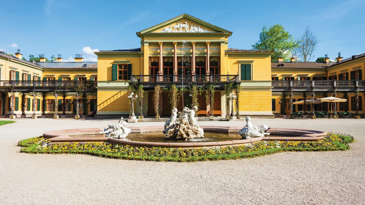The yellow neoclassical Kaiservilla at Bad Ischl behind an ornamental fountain and formal gravel forecourt