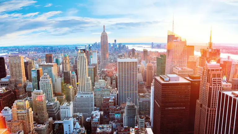 The Manhattan skyline at golden hour, the Empire State Building standing among the densely packed skyscrapers