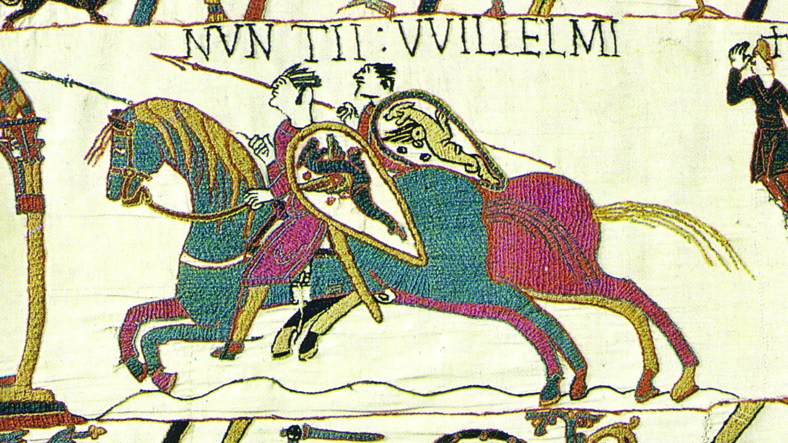 An embroidered medieval scene of horsemen with a Latin inscription above on linen.