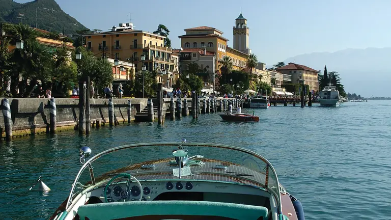 A wide view across Lake Garda, the largest lake in Italy, with the surrounding alpine foothills above the still water