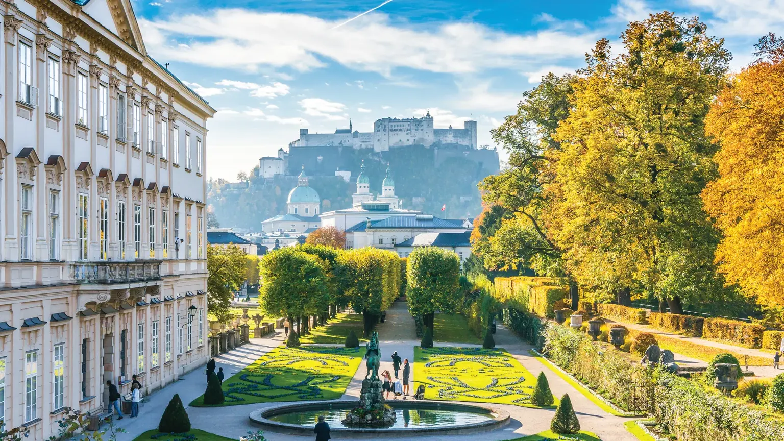The formal parterre of the Mirabell Gardens in Salzburg in autumn, the Hohensalzburg Fortress on its hill in the distance